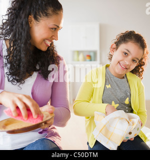 Madre e figlia piatti di essiccazione insieme Foto Stock