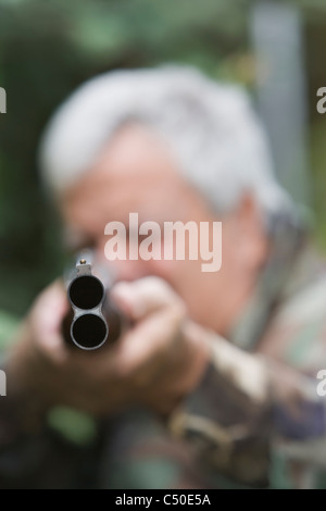 Senior uomo cileno fucile da caccia di puntamento Foto Stock