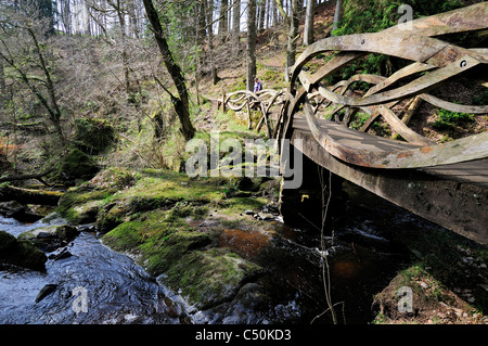 Signora escursionista attraversa "decorative di ponte; l' oltre il Linn sul percorso di Hareshaw Linn ( vicino a bellingham) Northumberland Foto Stock