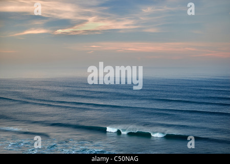 Sunrise e nuvole con onde. Cannon Beach. Oregon Foto Stock