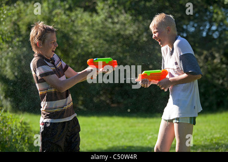 Due giovani ragazzi giocare con le pistole ad acqua Foto Stock