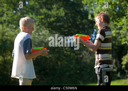 Due giovani ragazzi giocare con le pistole ad acqua Foto Stock