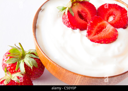 Fragola con lo yogurt in una ciotola di legno Foto Stock