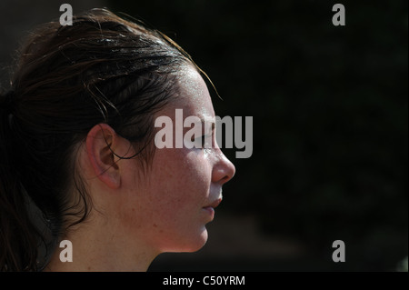 Giovane donna cercando accaldato con sudore sul forehaed dopo la corsa mattutina in temperatura calda Foto Stock