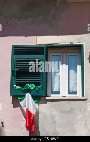 Un sgualcito bandiera italiana pende da una verde tradizionale persiana in Monterosso, Cinque Terre Liguria, Italia, Europa. Foto Stock