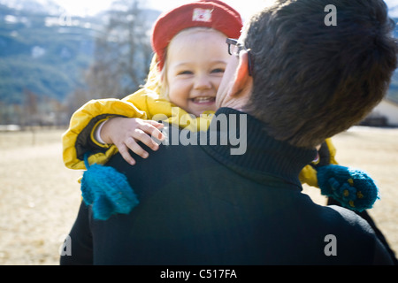 Padre che trasportano Bambina, baby ragazza sorridente Foto Stock