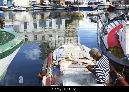 Africa, Tunisia, Bizerta, antico porto canale, Porto, Fisherman rammendo rete da pesca Foto Stock