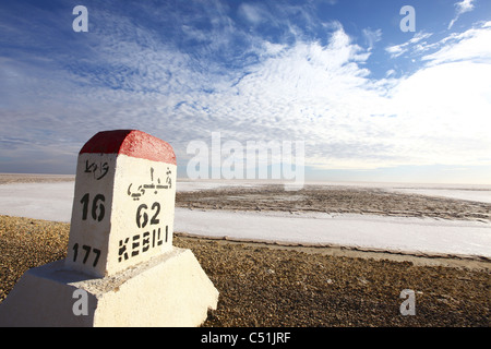 Africa, Tunisia, Chott El Jerid, piatto Dry Salt Lake, autostrada tra Tozeur e Kebili, distanza cartello Foto Stock