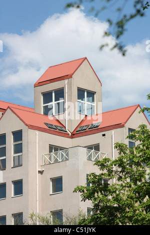 Multipiano edificio residenziale con un tetto rosso contro il cielo Foto Stock