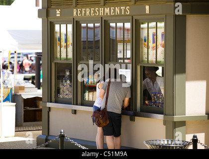 Una giovane coppia in attesa presso la finestra di concessione Foto Stock