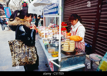 Venditore ambulante sulla strada musulmani preparare un dolce leccornia, Xian, Shaanxi, Cina Foto Stock