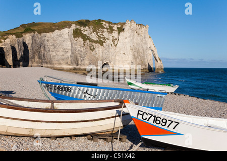 Scogliere e arco noti come porte d'Aval a Étretat, Normandia, Seine-Maritime, Francia. Con la sardina barche di pescatori sulla spiaggia. Foto Stock