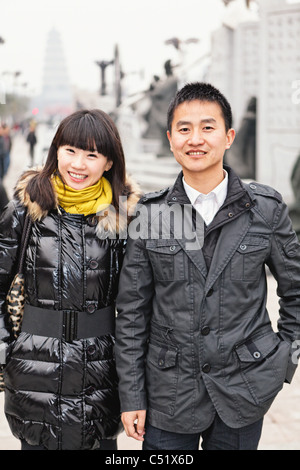Giovani cinesi giovane a piedi e sorridente in strada, Xian, Cina Foto Stock