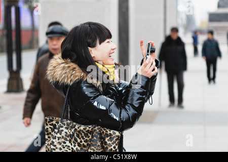 Giovane donna cinese per fotografare e ridere, Xian, Cina Foto Stock