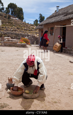 Uomo in abito tradizionale lavaggio delle lane su Isla Taquile, il lago Titicaca, Perù Foto Stock