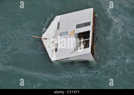 Vista aerea di una casa alla deriva al largo della costa Nordest del Giappone, 14 marzo dopo il terremoto e lo tsunami. Foto Stock