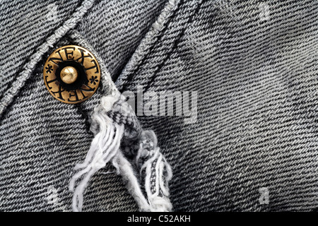 Dettaglio della tasca di area e prigioniero di metallo su una coppia di sbiadito e indossato il prossimo grigio (grigio) jeans denim Foto Stock