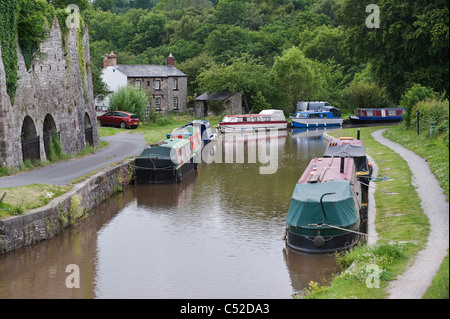 Strette barche ormeggiate accanto al Victorian fornace di calce sulla Monmouthshire e Brecon Canal vicino al villaggio di Llangattock Powys Galles del Sud Foto Stock