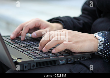 Le mani la digitazione su computer portatili Tastiera vicino fino Foto Stock
