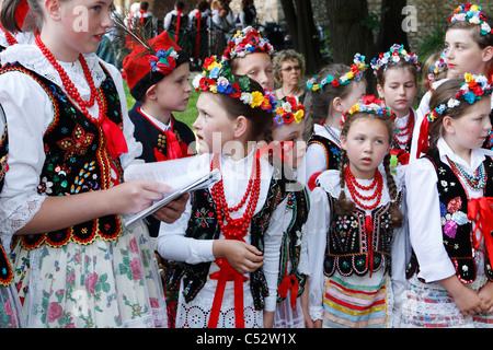 Un gruppo di bambini in tradizionale stile di Cracovia costumi folcloristici durante una performance musicale. Foto Stock