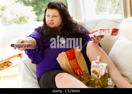 Donna di mangiare cibo grasso Foto Stock