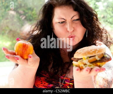 Donna di mangiare cibo grasso Foto Stock