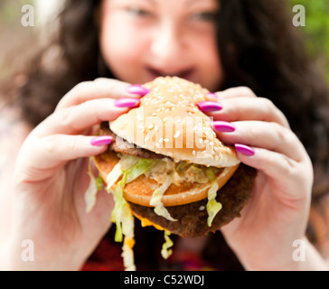 Donna di mangiare cibo grasso Foto Stock