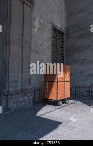 Un rullo di legno intorno al carrello che contiene una strada di mercanti di merci si siede parcheggiata per la sera a Firenze, Italia. Foto Stock