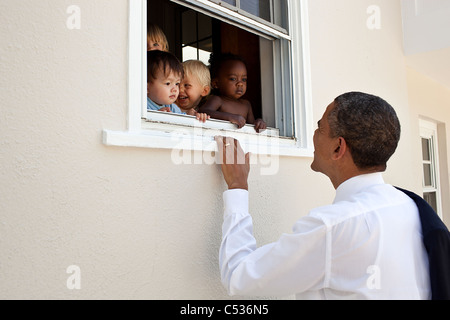 Il presidente Barack Obama saluta i bambini in un giorno la facilità di cura adiacente alla figlia Sasha's school di Bethesda, MD Foto Stock