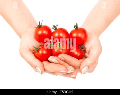 Pomodori ciliegia su un ramo verde in mani femminili su bianco Foto Stock