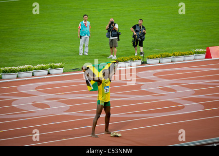 PECHINO, CINA: Usain Bolt che regge la bandiera giamaicana dopo aver vinto lo Sprint maschile da 100 metri ai Giochi Olimpici Foto Stock