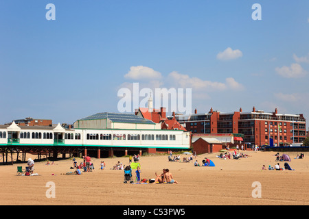 Lytham St Annes, Lancashire, Inghilterra, Regno Unito. I turisti sulla spiaggia sabbiosa dal molo in località balneare Foto Stock