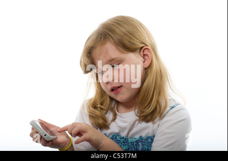 Ragazza di età primaria giocando con un iphone/ipod touch contro un bianco semplice sfondo per studio. Foto Stock