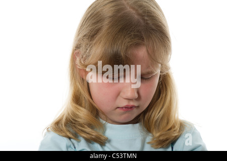 Ragazza giovane di età primaria cercando turbare o infelice contro la carta bianca comune e nuova di sfondo per studio. Foto Stock