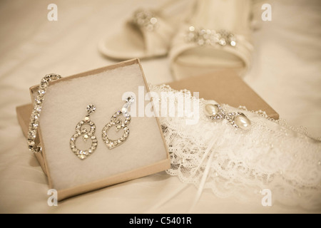 Brides jewelery compresi orecchini collana garter e scarpe sul foglio bianco Foto Stock