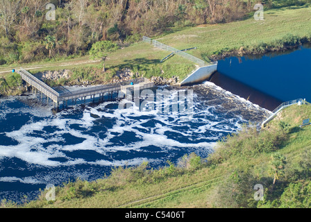 Weir sul canal con acqua che scorre sopra Foto Stock