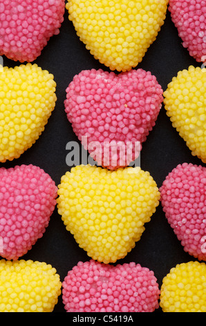 Gruppo di a forma di cuore ad Jelly Beans e rosa e giallo Foto Stock