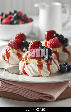 Nidi di meringa con frutta e della crema di latte Foto Stock