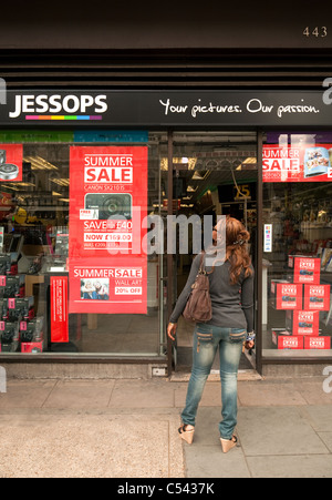 Una donna che guarda la segnaletica per una vendita a Jessops archivio fotografico, Strand, Londra UK Foto Stock