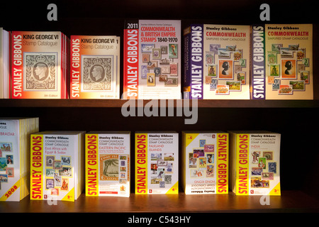 Cataloghi di timbro sul ripiano a Stanley Gibbons store sullo Strand, Londra UK Foto Stock