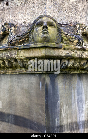 Un volto angelico, capovolto, scolpito su una tomba nella necropoli, Glasgow, Scotland, Regno Unito Foto Stock