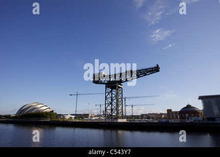 Gru edili in Glasgow sullo Scottish Hydro sito Arena, Glasgow, Scotland, Regno Unito. University tower all'orizzonte. Foto Stock