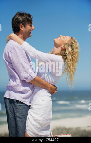 Giovane che abbraccia ogni altro sulla spiaggia Foto Stock