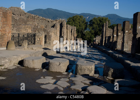 Una strada pavimentata con pietre miliari presso i ruderi della antica città romana di Pompei, Campania, Italia Foto Stock