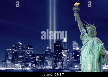 Inferiore dello Skyline di Manhattan, la Statua della Libertà e le torri delle luci di notte Foto Stock