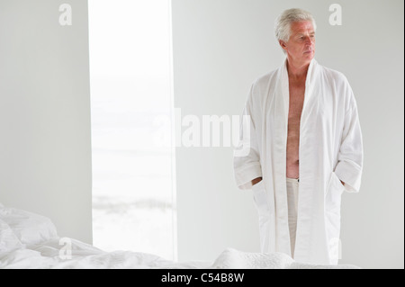 Senior uomo indossando un morbido accappatoio Foto Stock