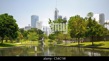 KLCC Park presso le Petronas Twin Towers di fronte alla skyline con edifici di uffici e hotel di Kuala Lumpur, Malesia, Southeas Foto Stock