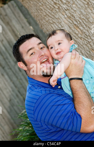 Un padre gioca con il suo 8 mese vecchio bambina all'esterno. Foto Stock