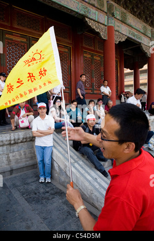 I turisti cinesi / tour di gruppo / parte turistica con una guida turistica / leader con bandiera, nella Città Proibita di Pechino, Cina. Foto Stock