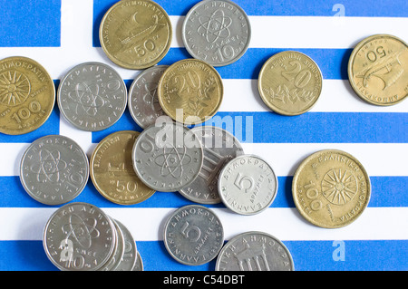 La dracma greca monete prevista su una bandiera greca. Foto Stock